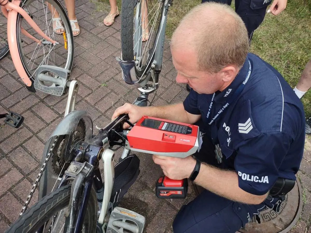 Policjant oznakowuje rower za pomocą urządzenia e-mark. To ważny krok, by zapobiec kradzieżom i ułatwić identyfikację.