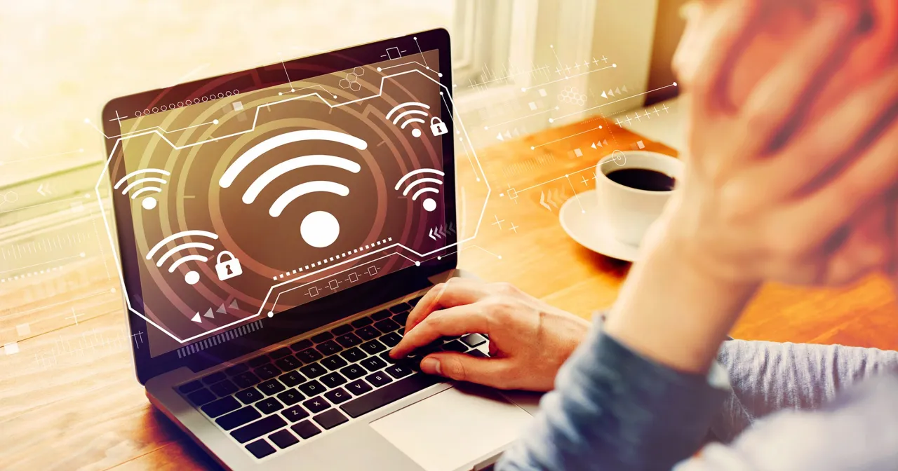 Osoba sprawdzająca urządzenia w sieci Wi-Fi na laptopie