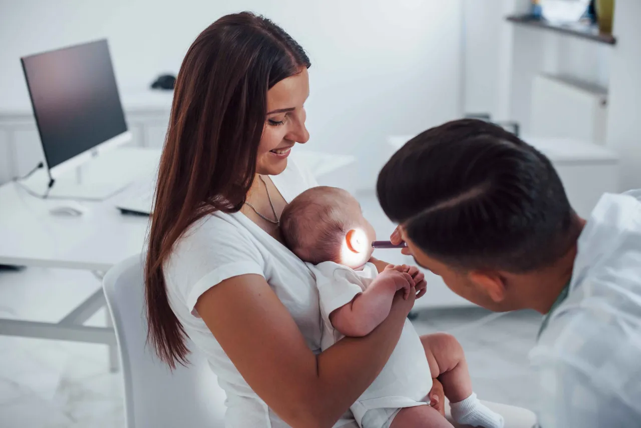 dziecko z zatkanym uchem, zaniepokojony rodzic