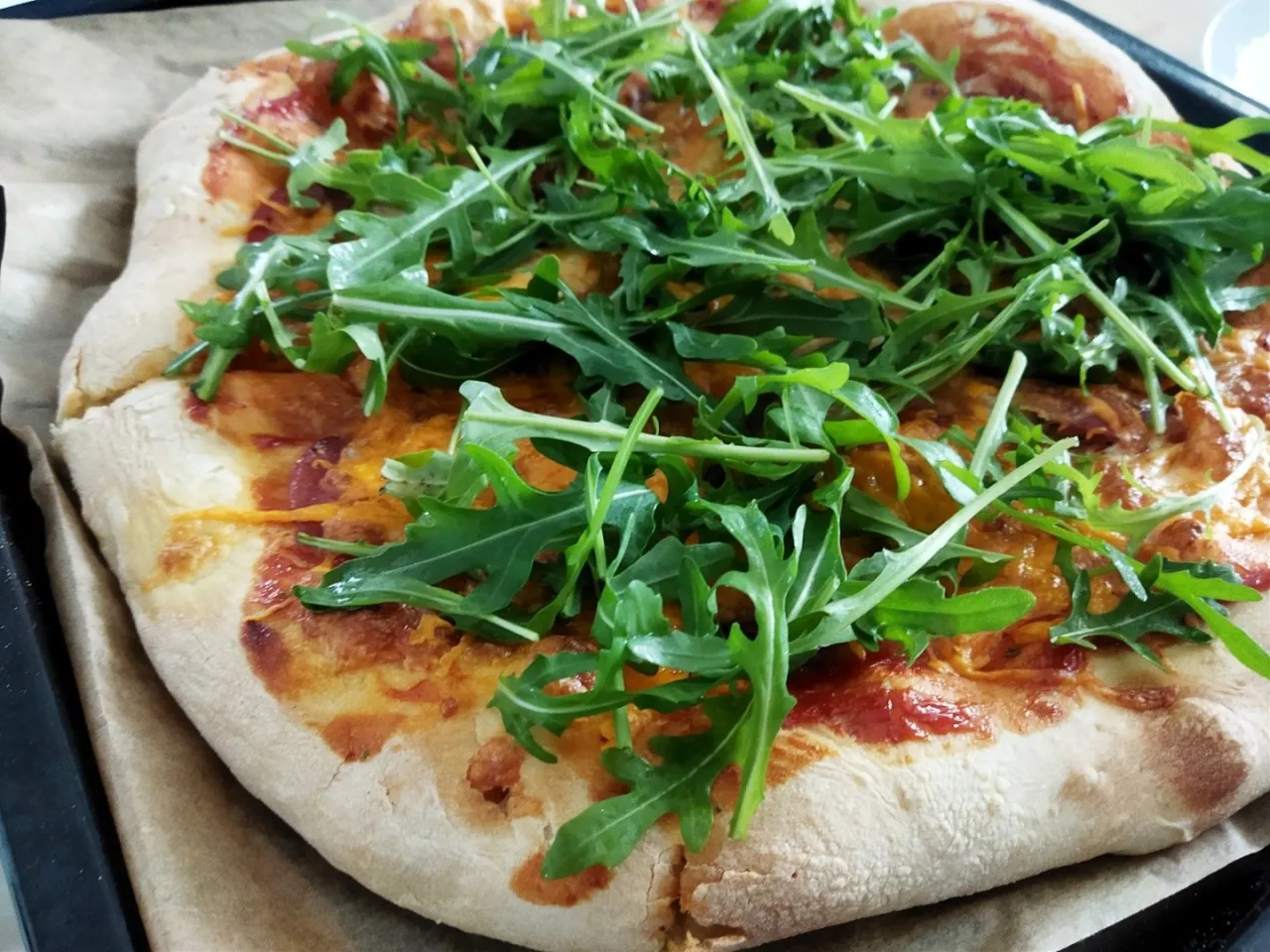 Pizza z salami i rukolą, zapieczona z serem. Idealne dodatki dla miłośnik&oacute;w ostrych smak&oacute;w.