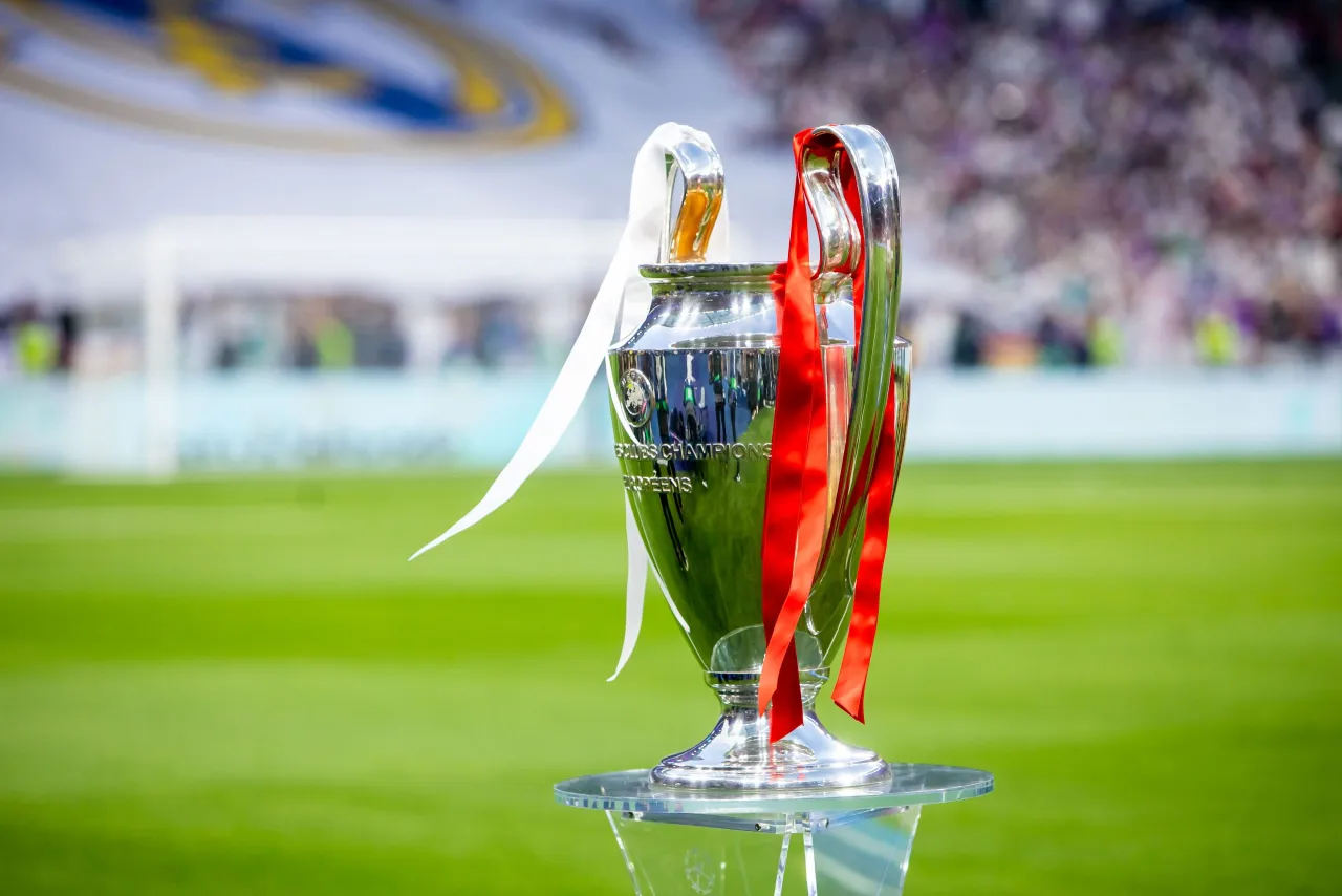 Trofeum Ligi Mistrz&oacute;w z czerwonymi i białymi wstążkami, symbol marzeń o zwycięstwie w Lidze Mistrz&oacute;w 2024.