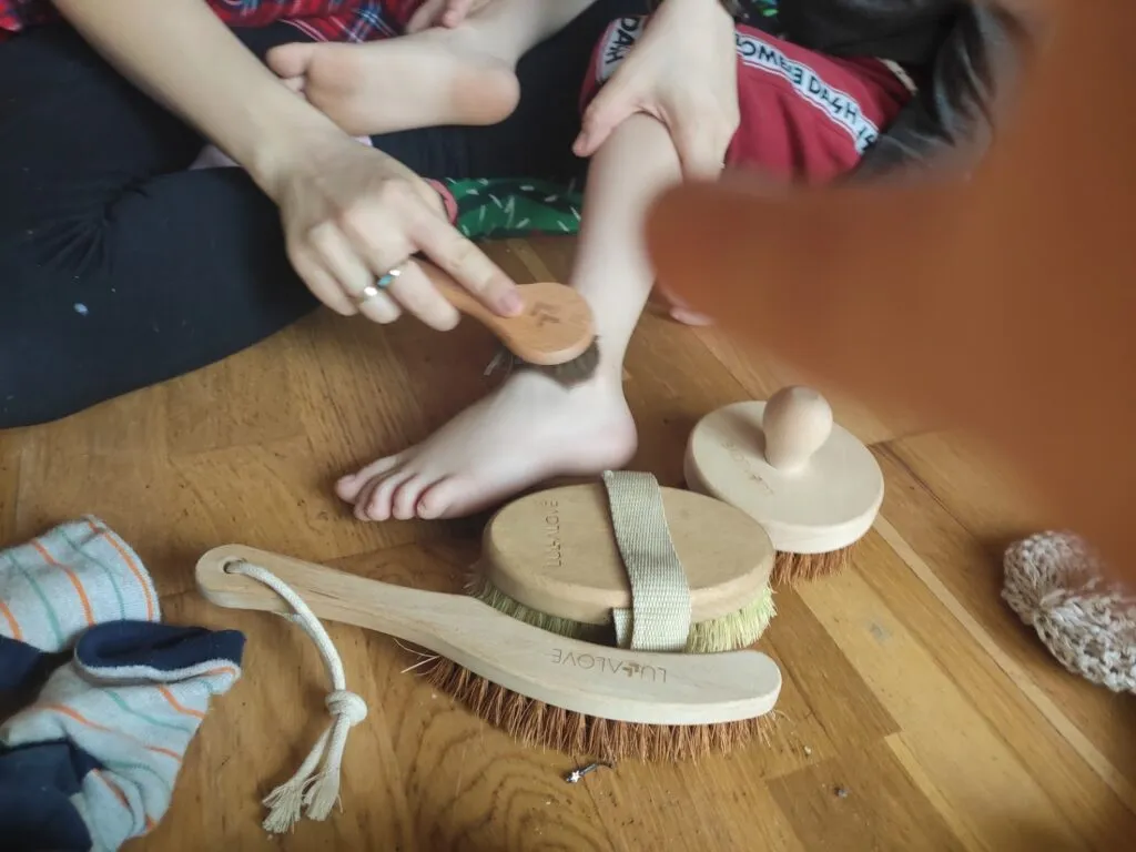 dziecko masowane szczotką sensoryczną