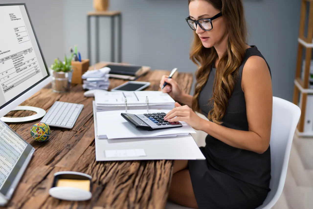 osoba sprawdzająca raport finansowy na laptopie