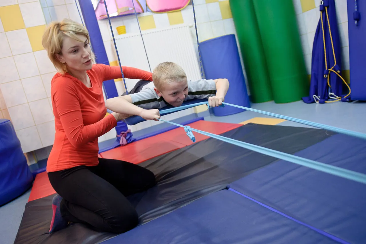 Terapeuta integracji sensorycznej pracuje z dzieckiem w gabinecie