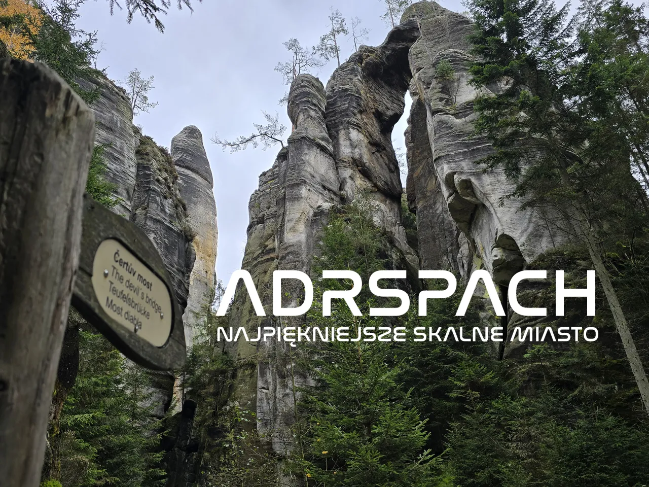 Imponujące skalne miasto w Czechach, Adršpach, z kamiennym łukiem i tabliczką 