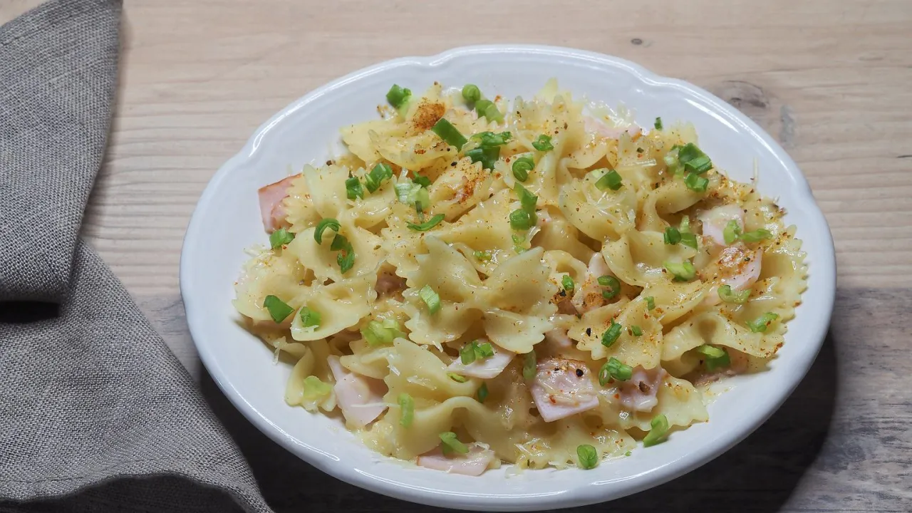 Makaron farfalle z szynką i szczypiorkiem w kremowym sosie. Idealne danie, gdy zastanawiasz się, co na obiad szybko i zdrowo.