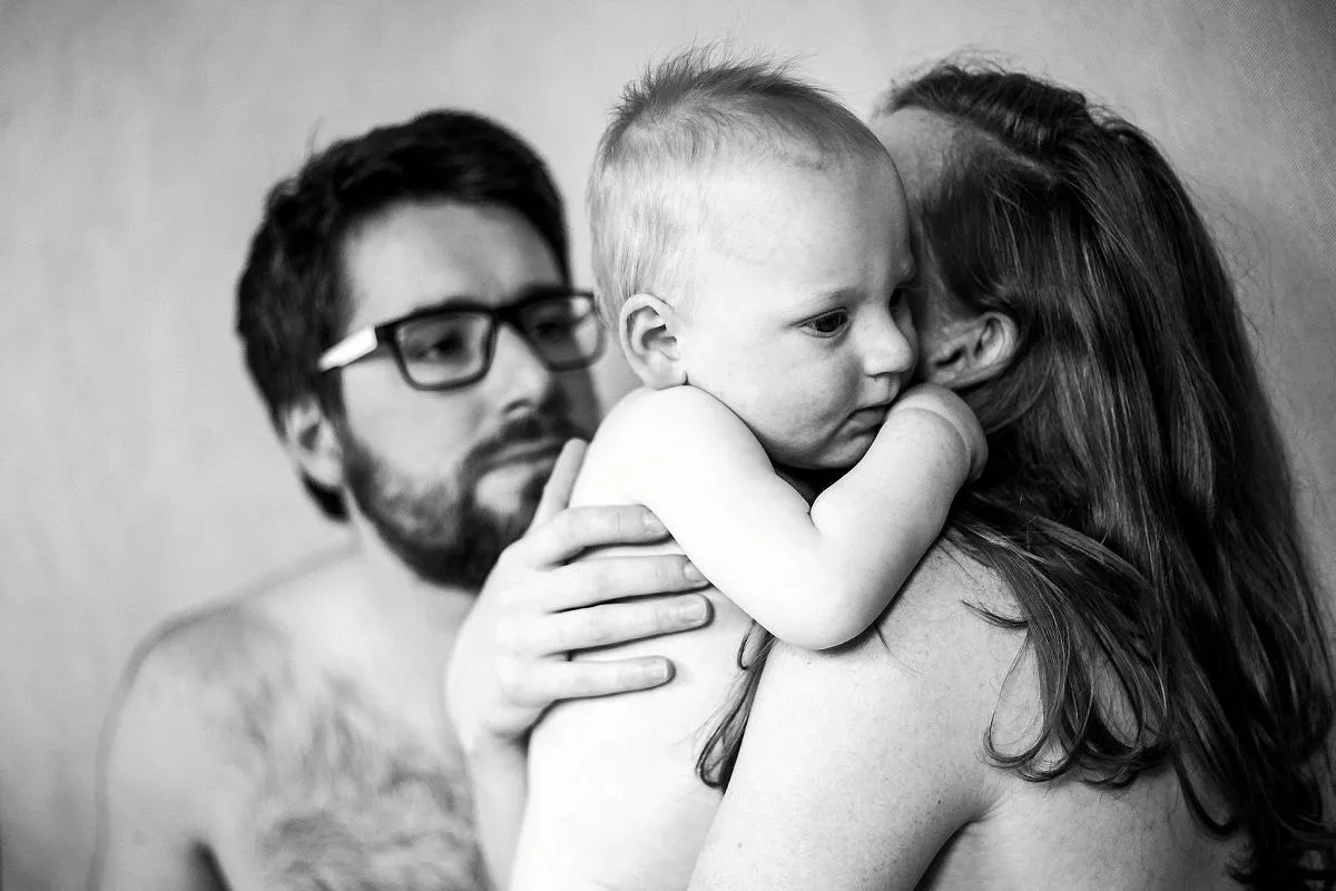 rodzic przytulający niemowlę z czułością