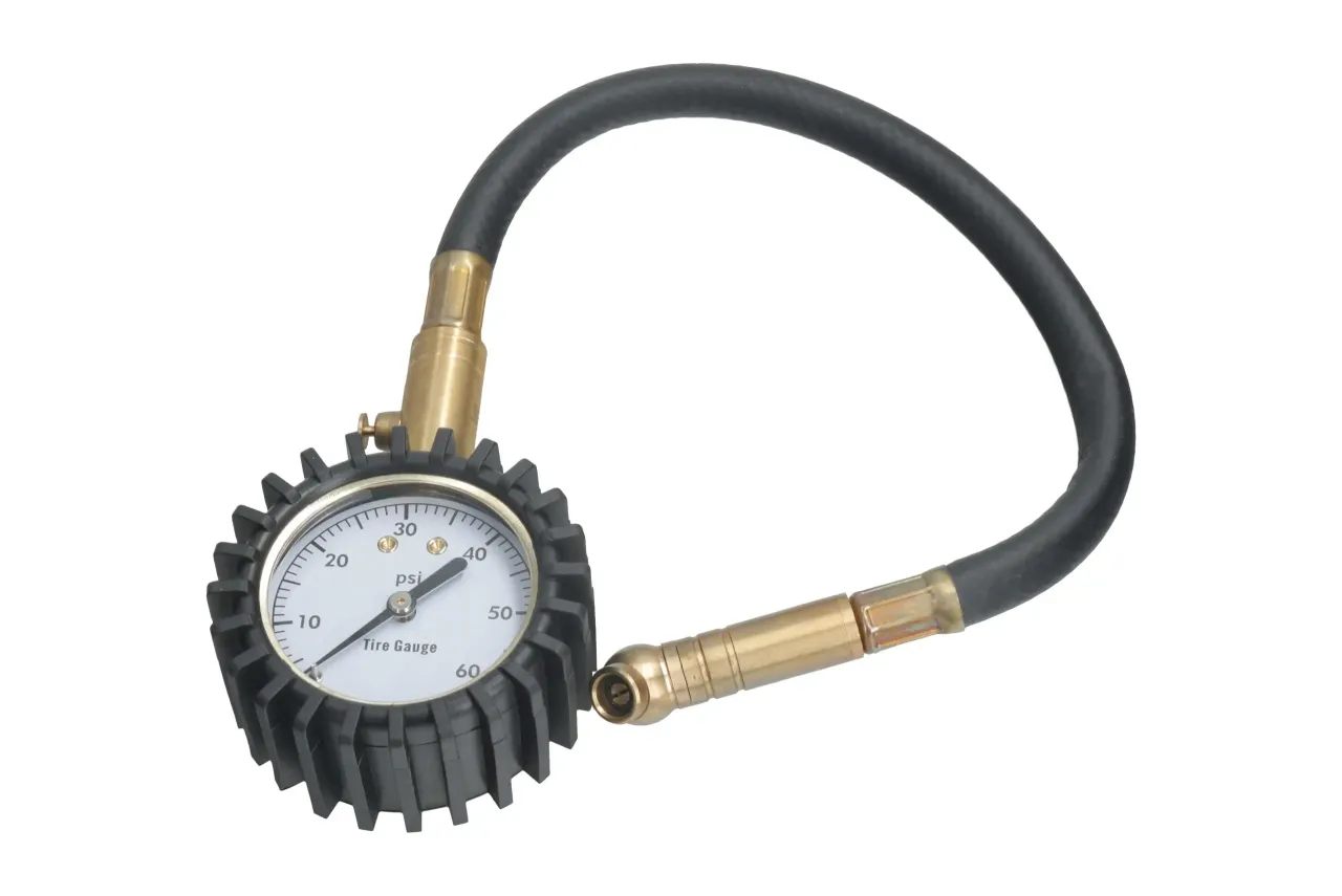 motocyklista sprawdzający ciśnienie w oponie manometrem