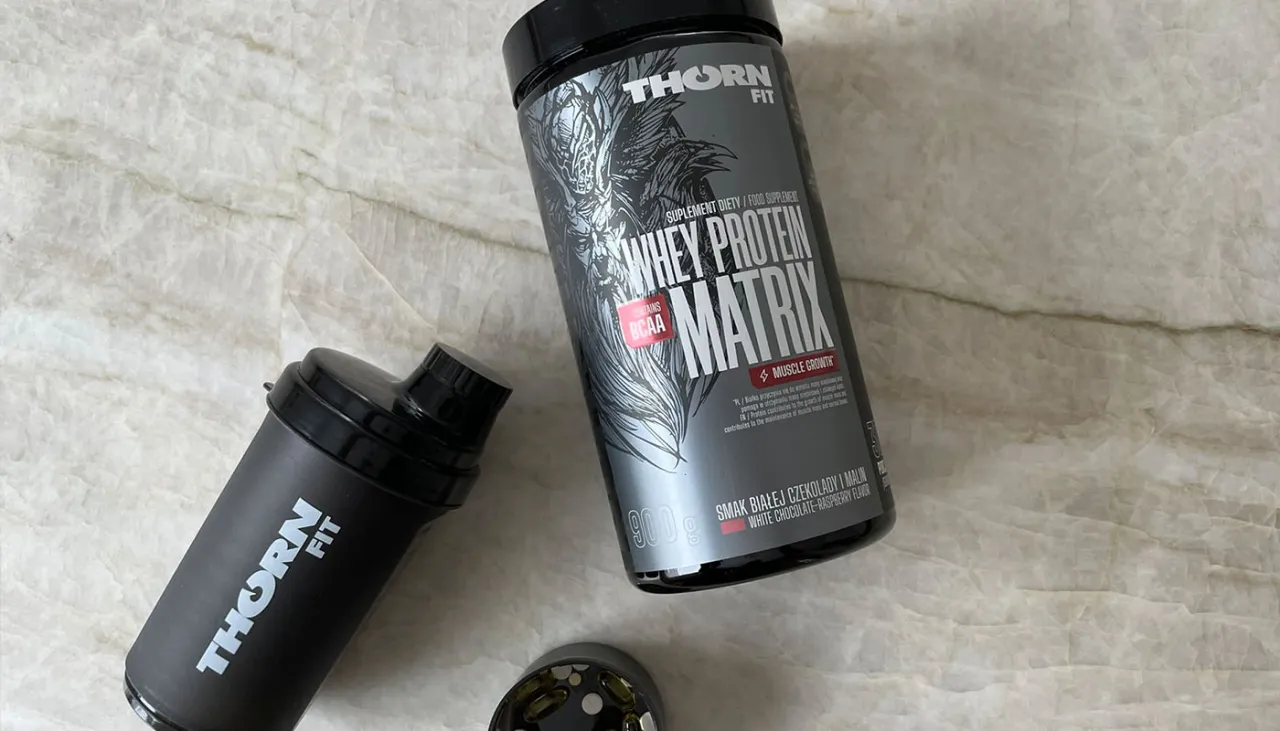 Pojemnik z odżywką białkową i shakerem. Białko po treningu to klucz do regeneracji i budowy masy mięśniowej.