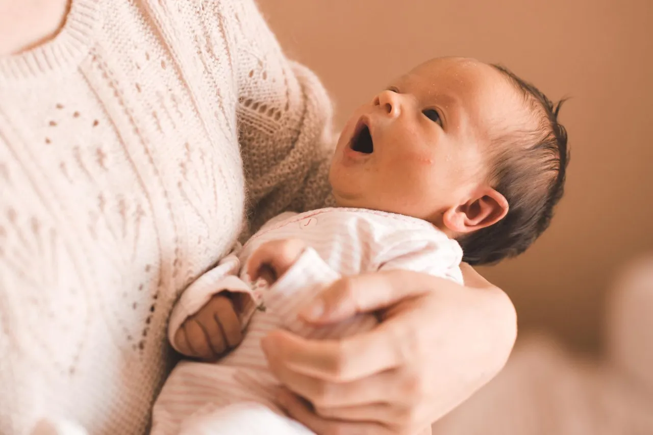 fizjoterapeuta pokazuje prawidłowe podnoszenie niemowlęcia