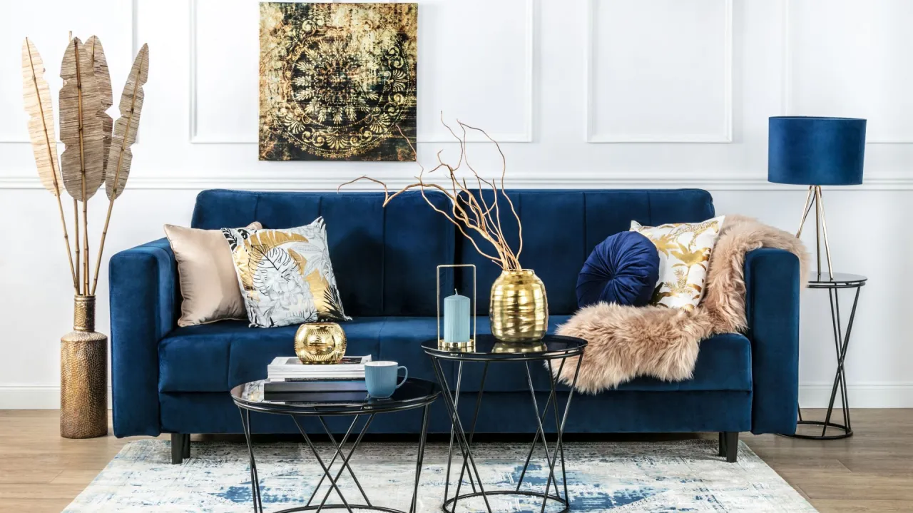 niebieska kanapa złote dodatki aranżacje
