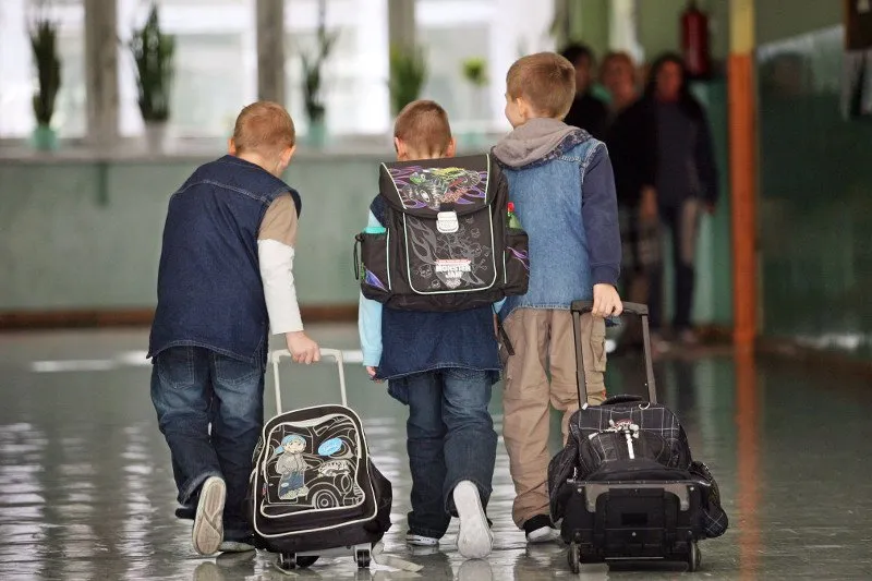 fizjoterapeuta pokazujący prawidłowe użycie plecaka na kółkach