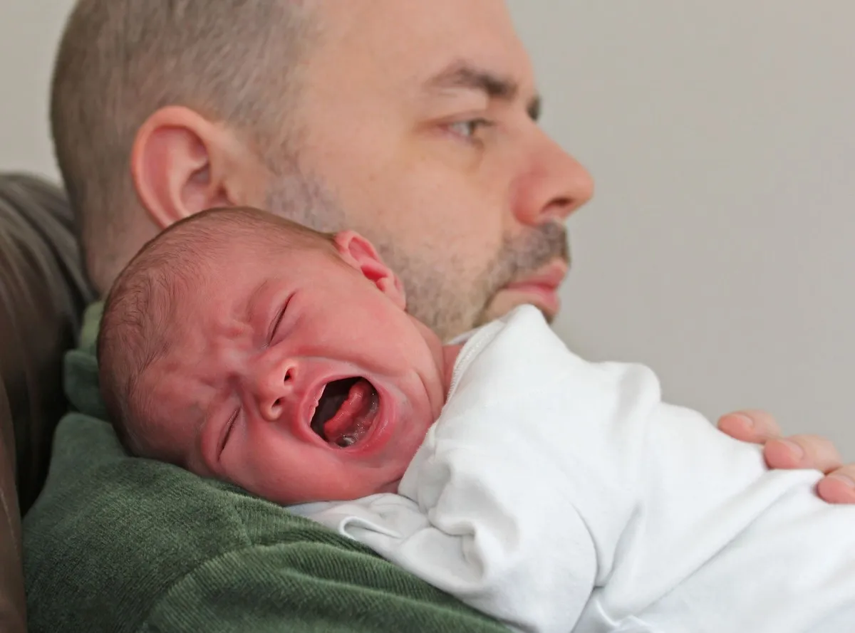 rodzic przytula płaczące niemowlę