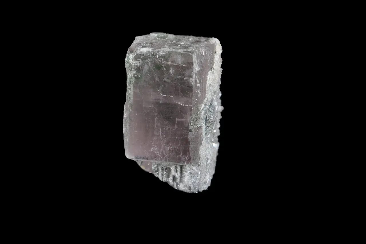 Przezroczysty kryształ z widocznymi wrostkami, przypominający gips.