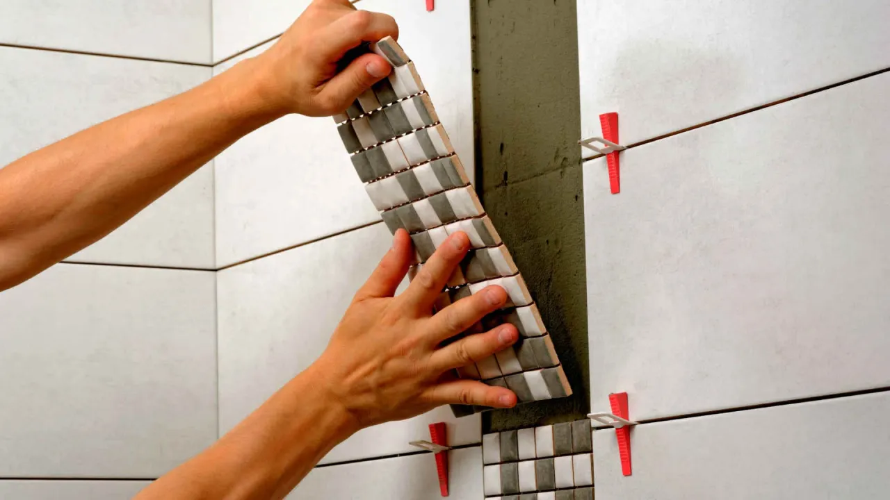 Układanie mozaiki z użyciem systemu poziomowania płytek. Czerwone kliny zapewniają idealnie równe fugi.
