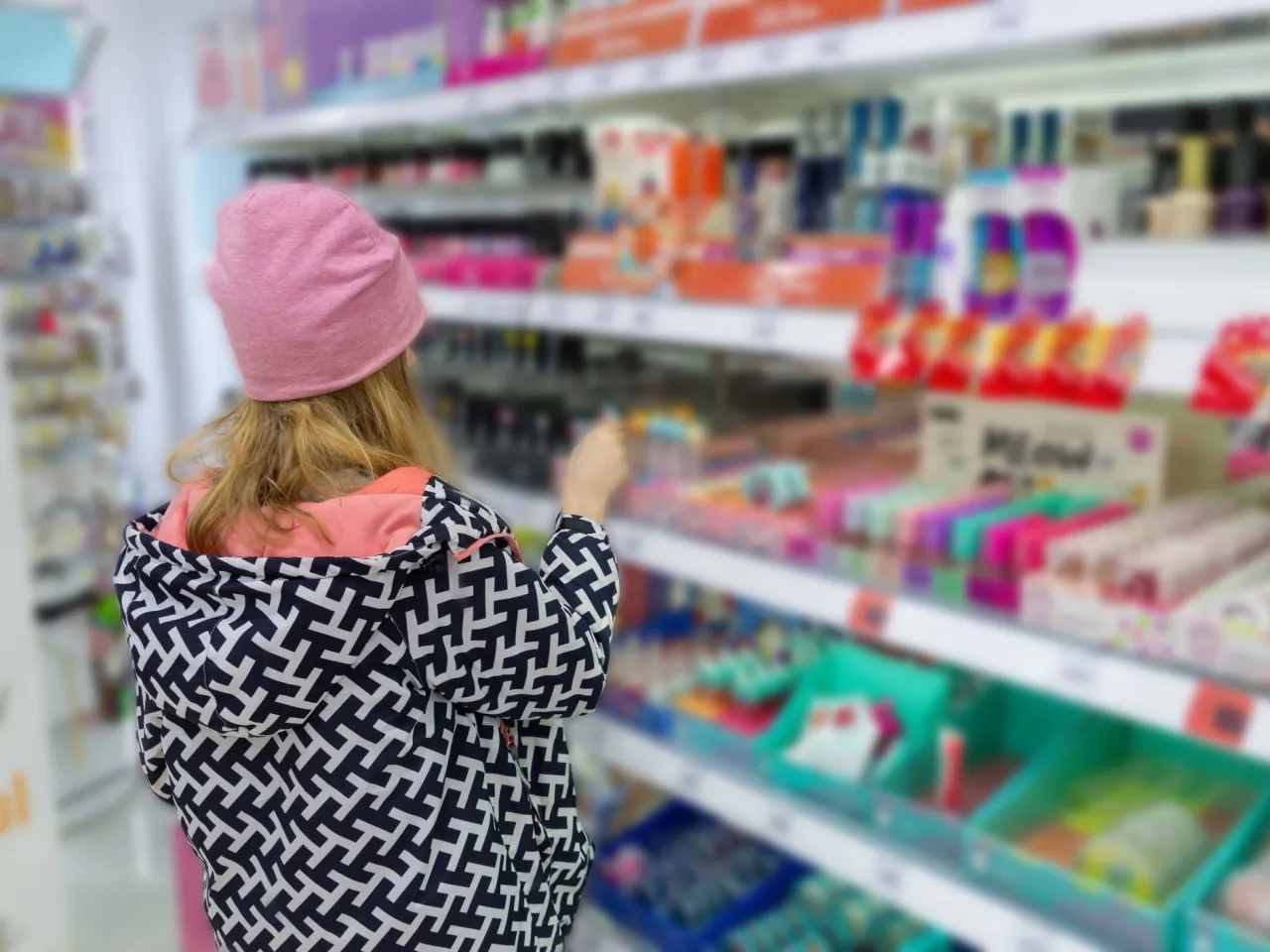 Teenager looking at skincare products in a Rossmann store aisle