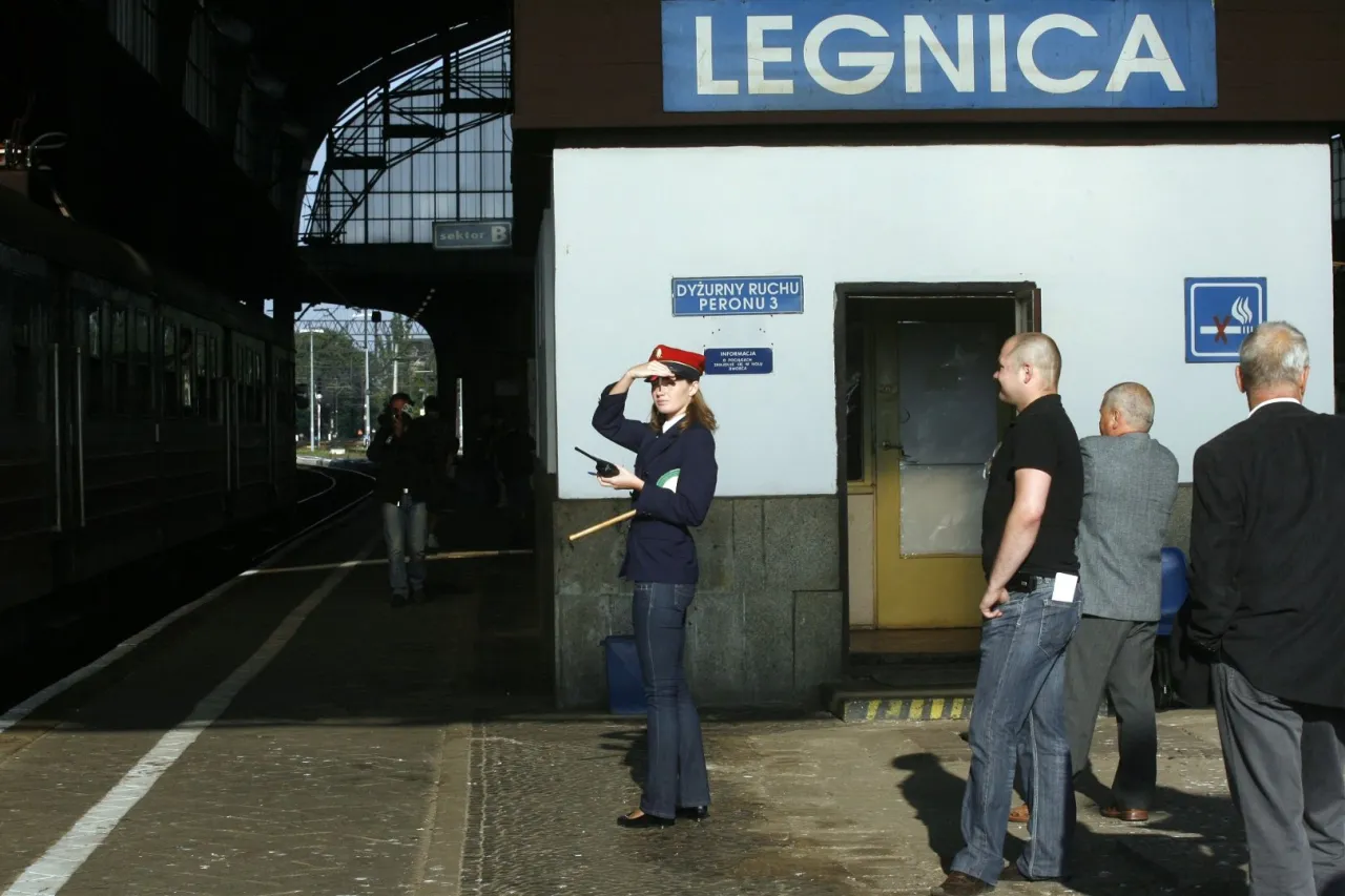Konduktorka PKP na peronie w Legnicy, zastanawia się, ile zarabia konduktor PKP.