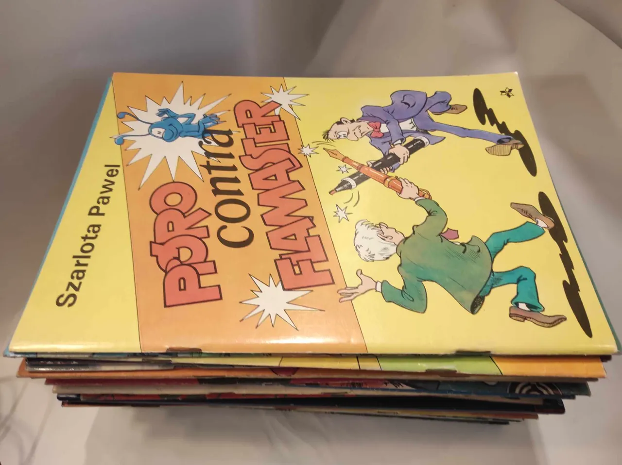 Stos komiks&oacute;w Szarloty Pawel. Na okładce jeden z nich, 