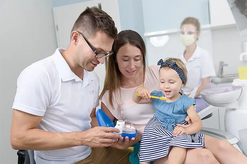 rodzic dziecko uśmiechnięty dentysta