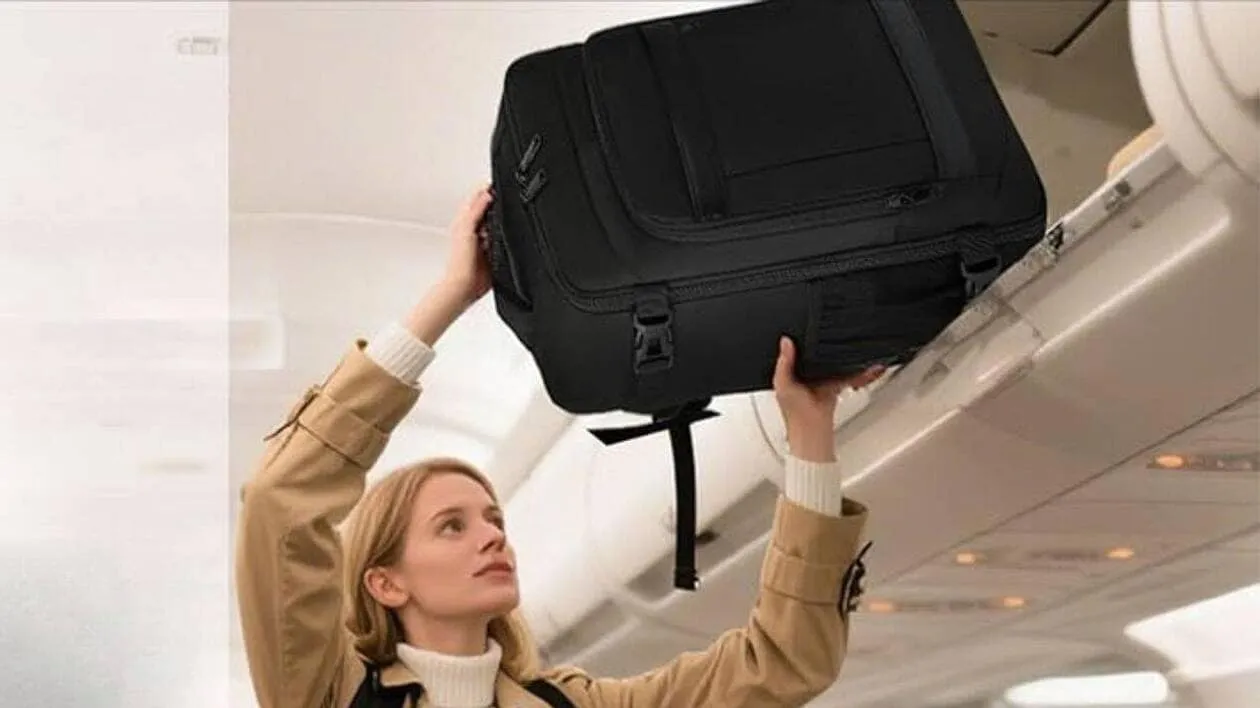 Personne gérant sa réservation easyJet sur un ordinateur portable avec une valise à côté