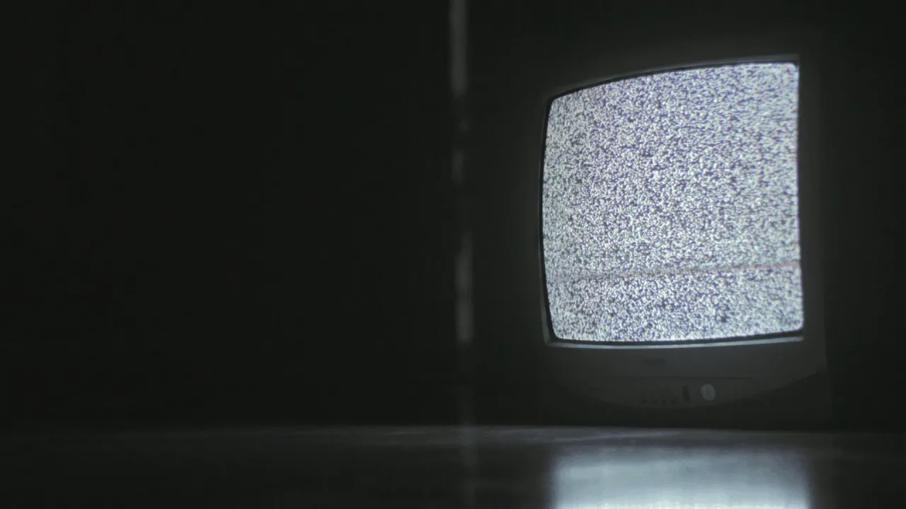 osoba oglądająca telewizor z komunikatem brak sygnału