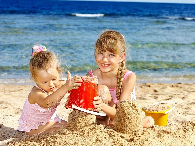 dzieci bawiące się na plaży lub w aquaparku nad morzem