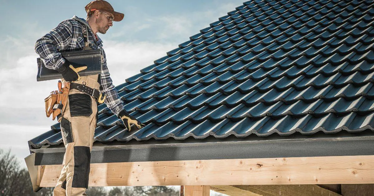 Nowoczesny dekarz na dachu z narzędziami