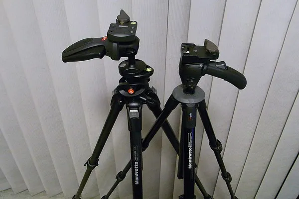 aparat fotograficzny obok statywu z widoczną głowicą i szybkozłączką