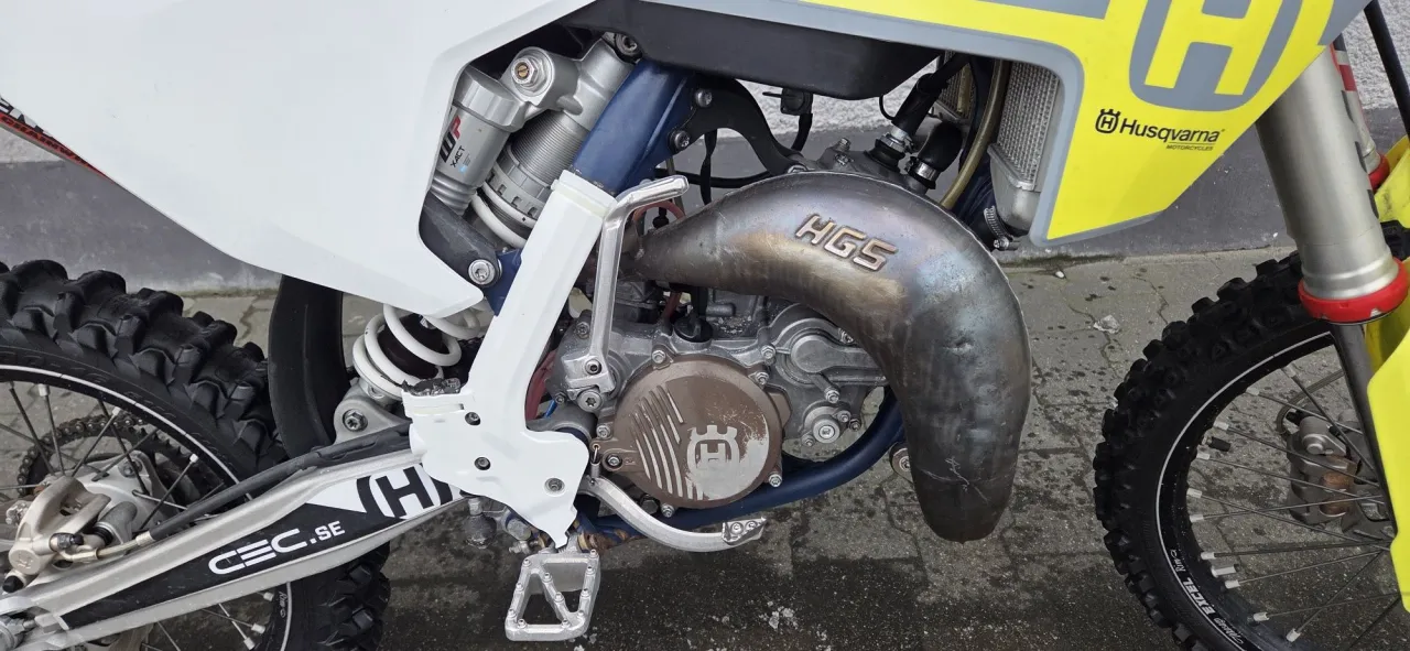 Silnik husqvarna 125 z wydechem HGS. Widoczny amortyzator WP XACT i logo Husqvarna.