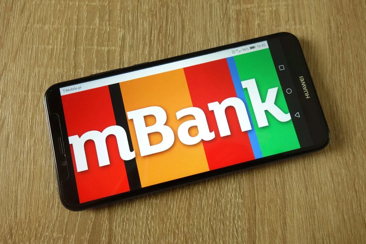 Smartfon z logo mBank na kolorowym tle. Dowiedz się, jak aktywować kartę mBank, korzystając z aplikacji mobilnej.