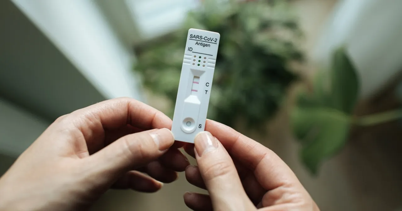 Pozytywny wynik testu COVID-19 i osoba z maseczką