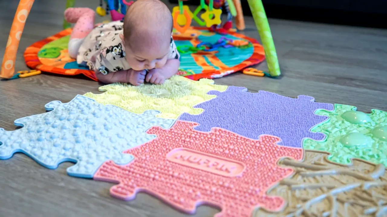 dziecko bawi się na macie sensorycznej Muffik