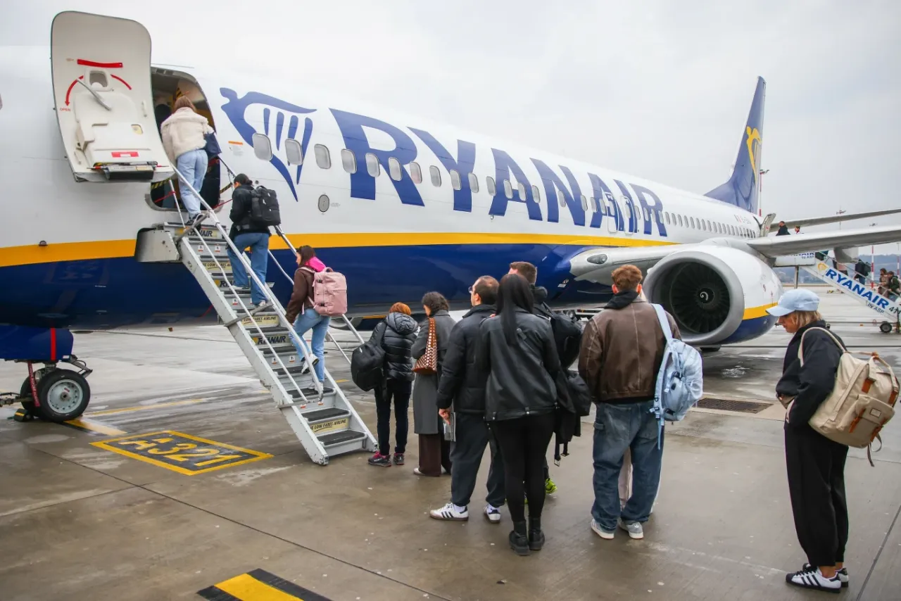 Pasażerowie wsiadają na pokład samolotu Ryanair. Linia oferuje tanie loty, bagaż podręczny i możliwość dokupienia dodatkowych usług.