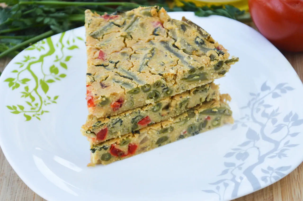 Pyszna wege kolacja: kawałki zapiekanki z fasolką szparagową i papryką na talerzu z motywem drzewa.