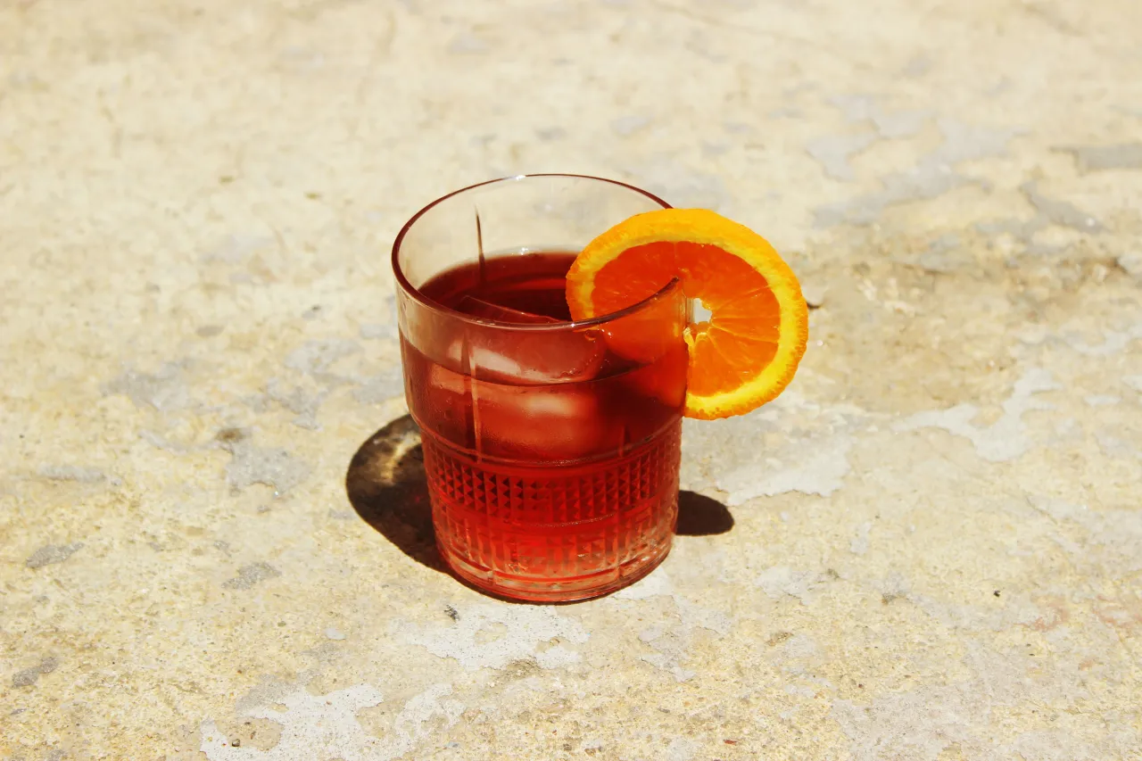 Negroni cocktail in bicchiere old fashioned con fetta d'arancia