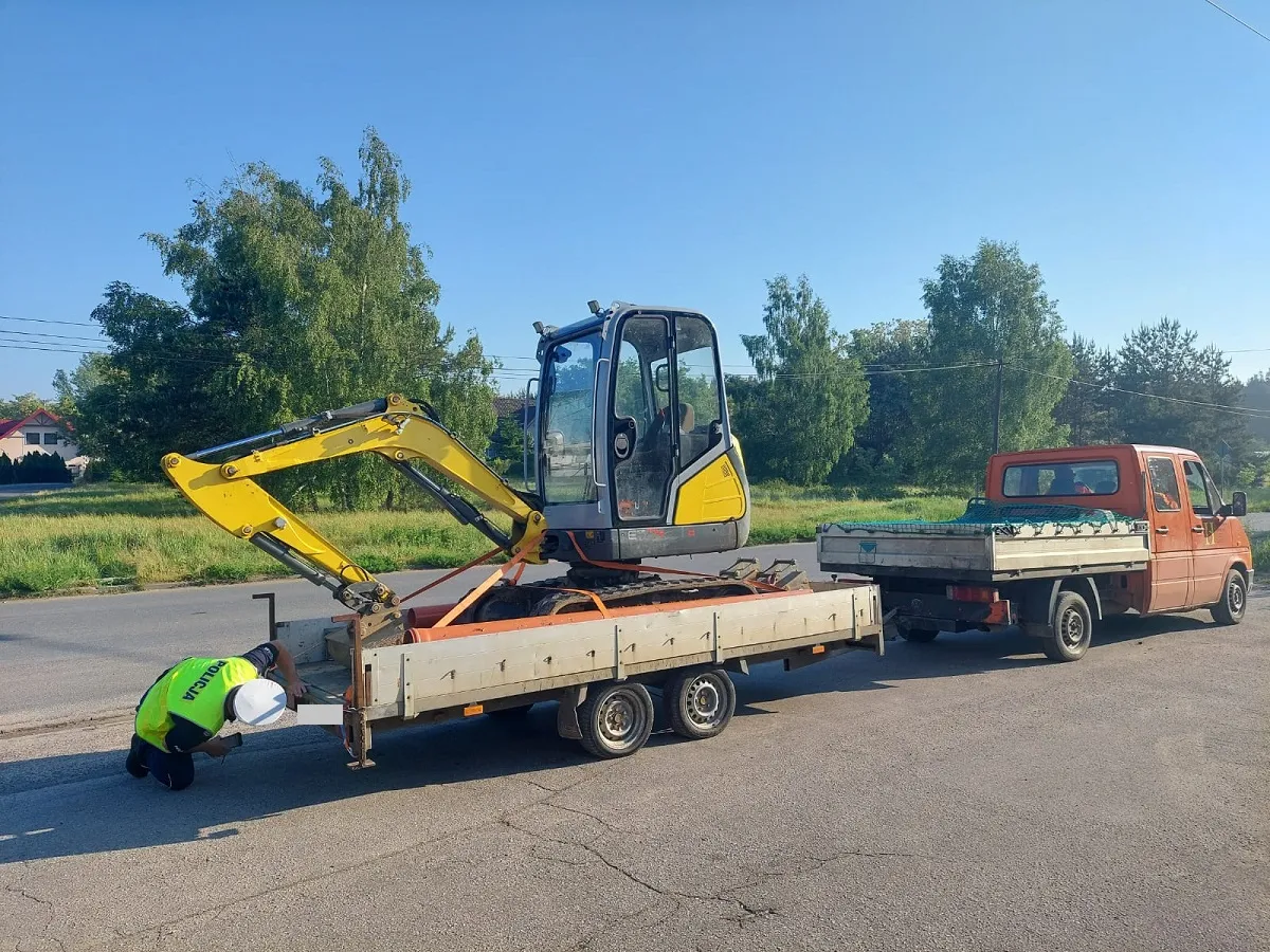 Policjant kontrolujący dokumenty kierowcy z przyczepą