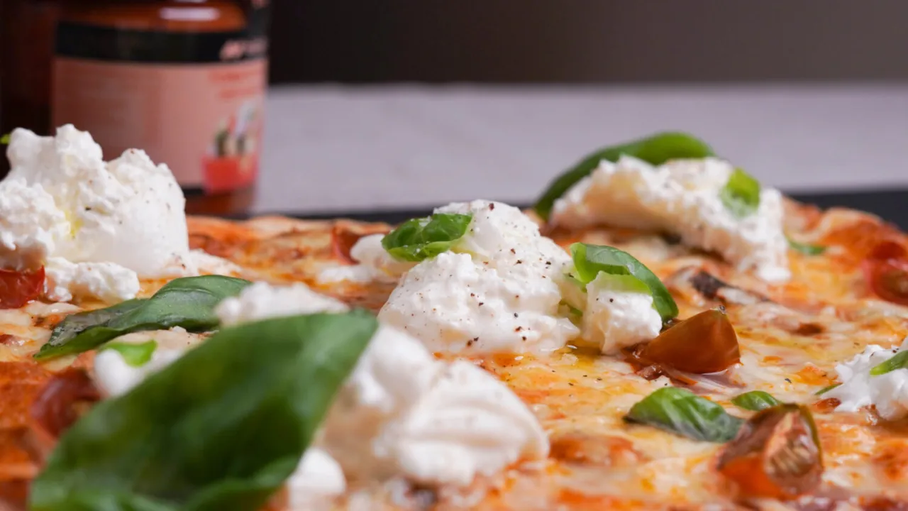 pizza vegana casera con queso derretido y albahaca fresca