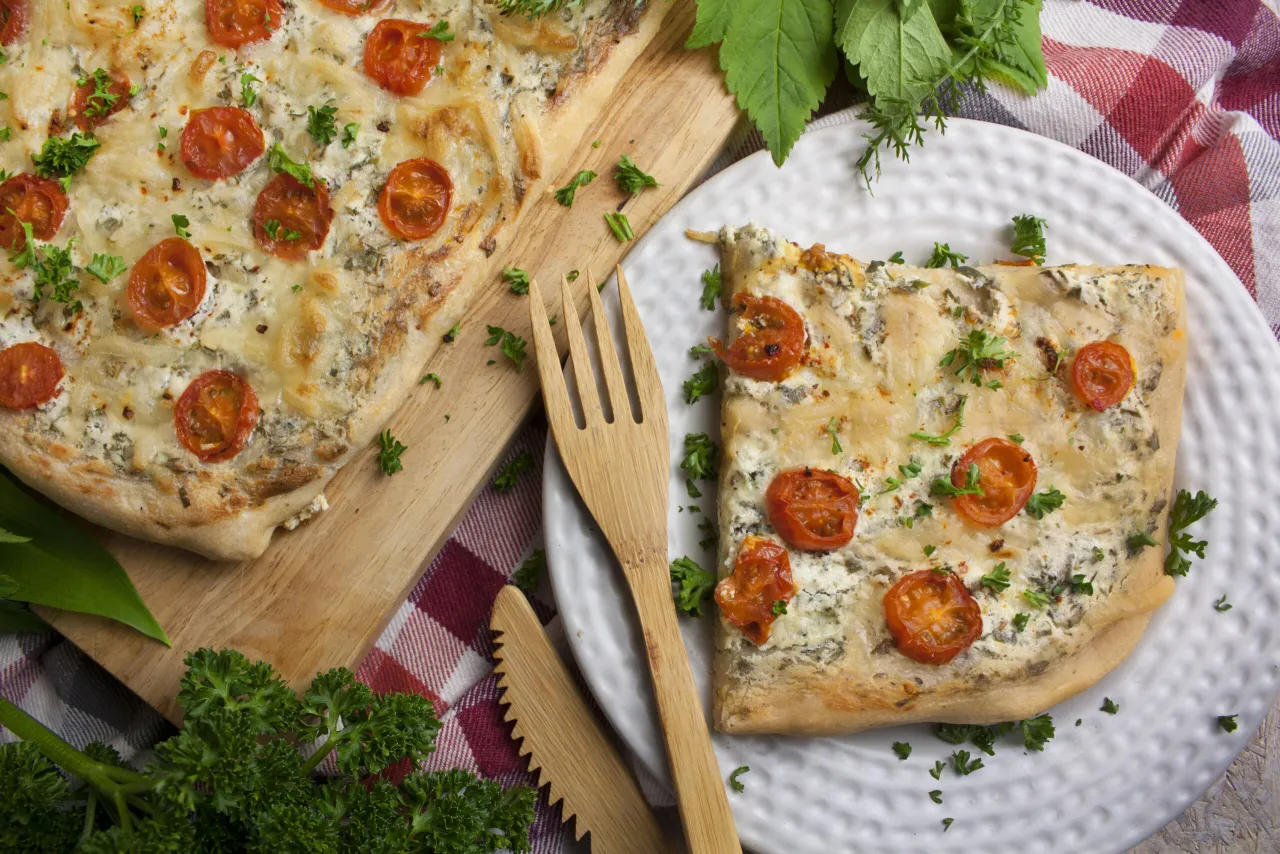 Frische Kräuter auf fertiger Pizza