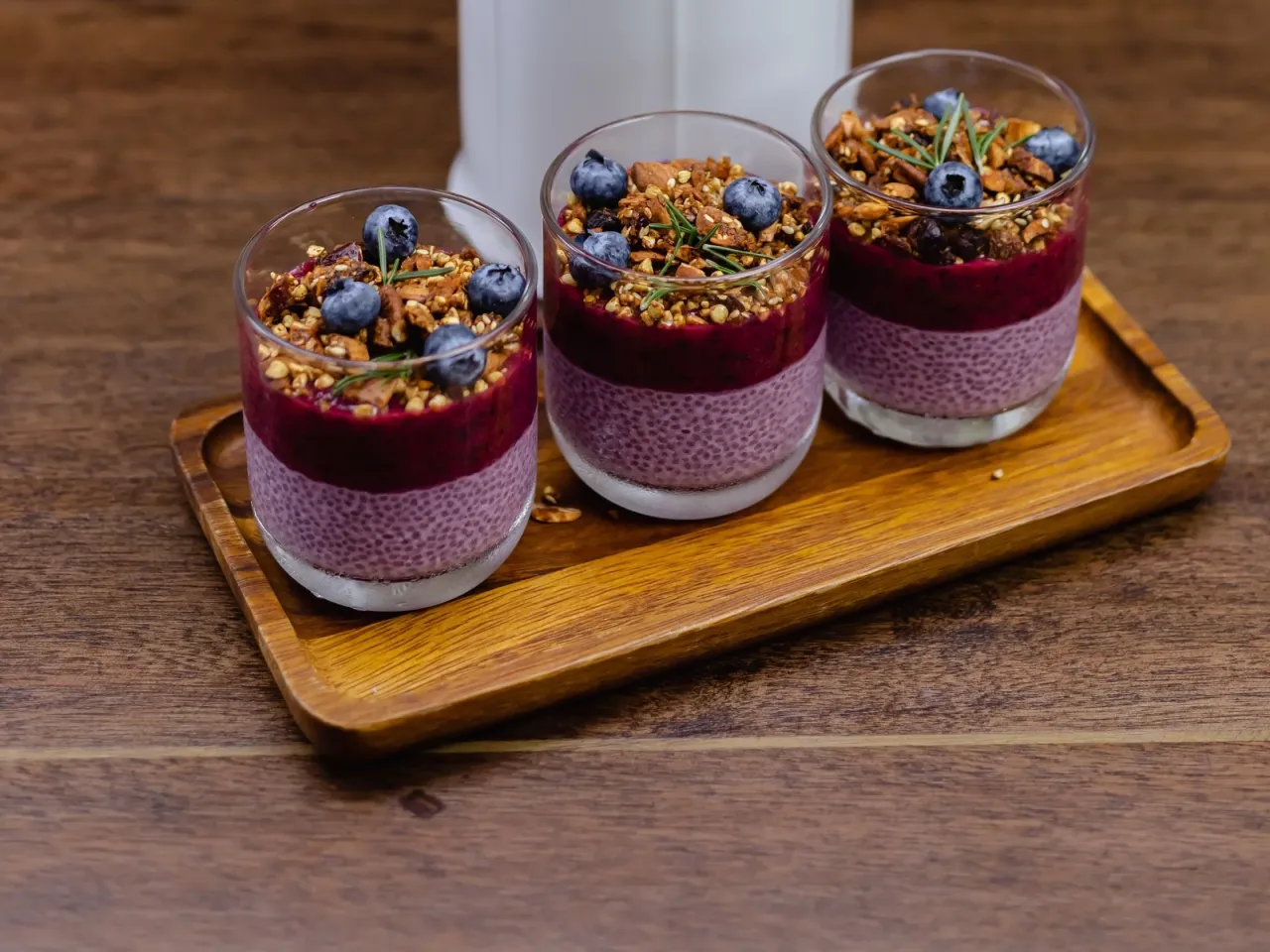 Szybki deser z niczego przepis: warstwy budyniu chia, jagód i chrupiącej granoli w szklankach.