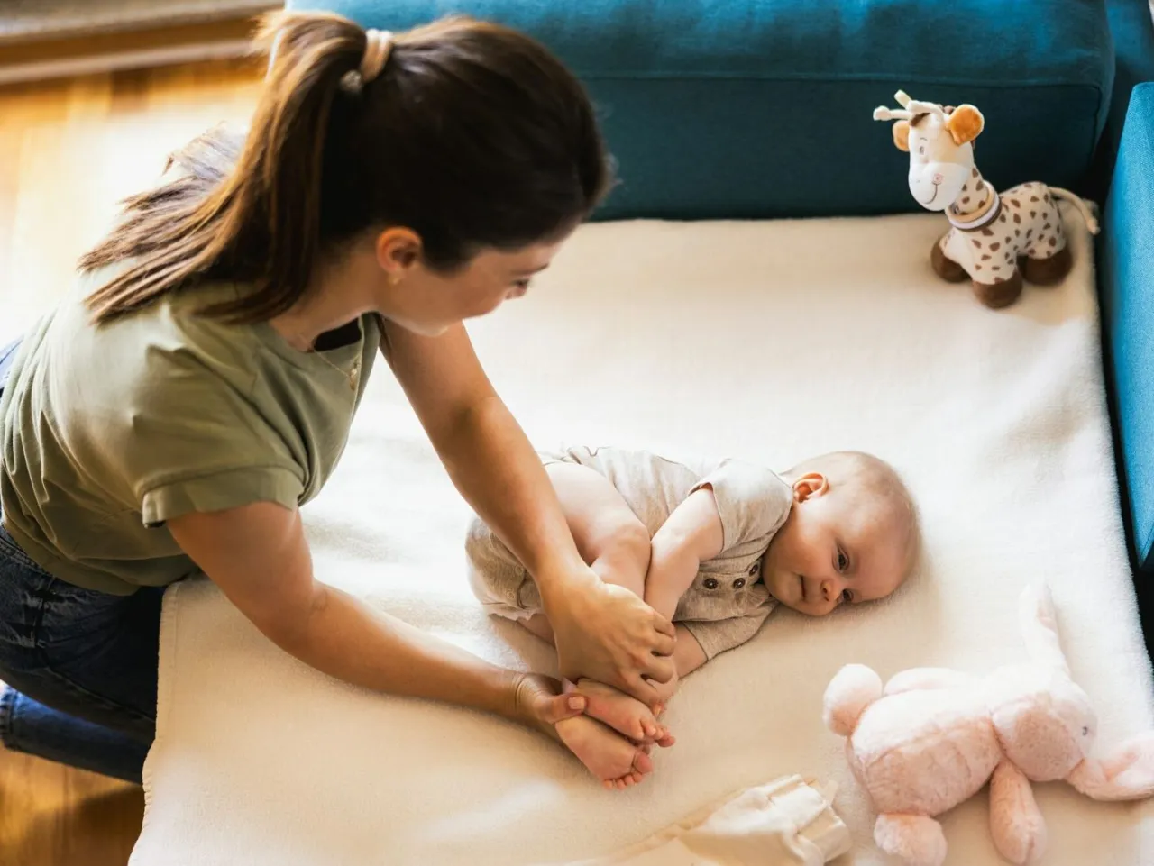 rodzic przytula niemowlę, zabawy rozwojowe niemowląt, rodzic bawi się z dzieckiem