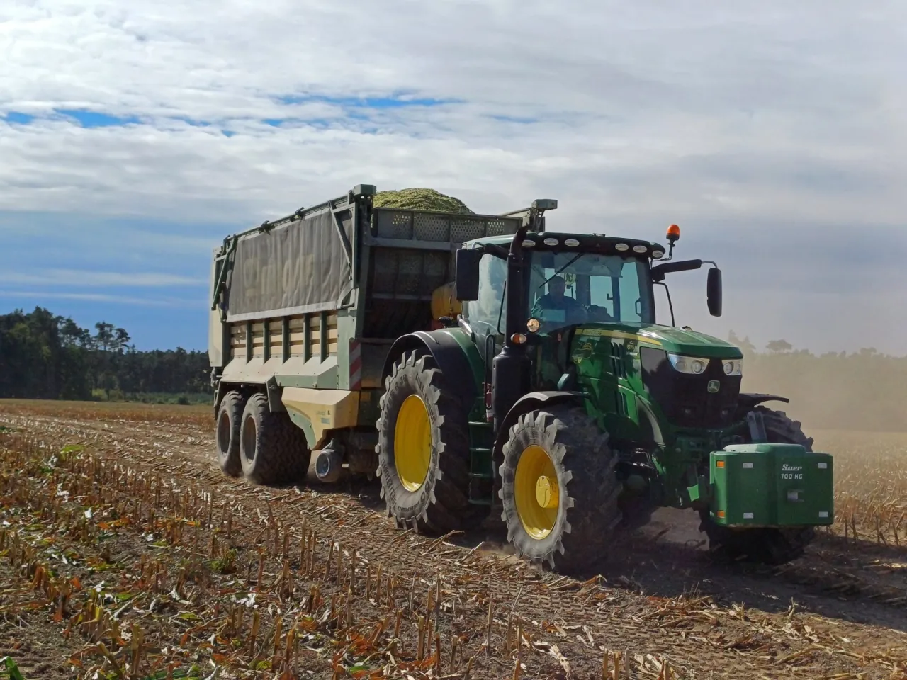 Rolnik sprawdzający silnik ciągnika przed zakupem