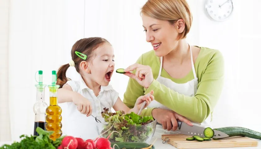 dziecko eksperymentuje z warzywami w kuchni