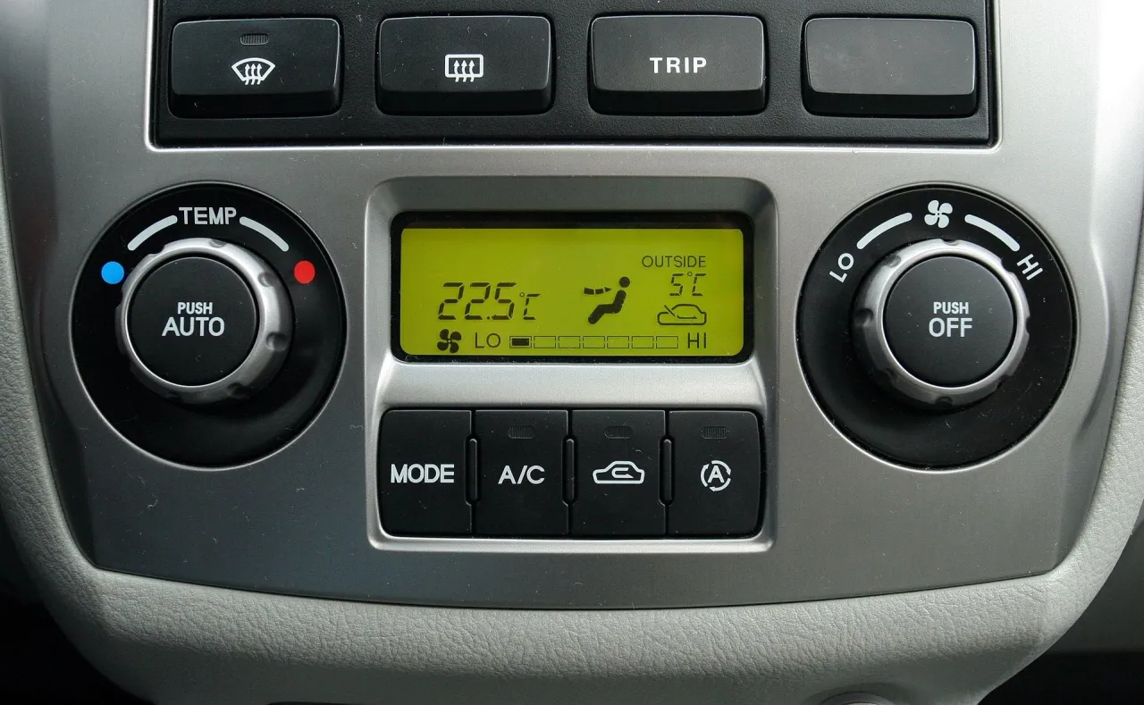 Wyświetlacz klimatyzacji pokazuje 22.5°C w kabinie i 5°C na zewnątrz. Brak ogrzewania w samochodzie, wentylator ustawiony na LO.