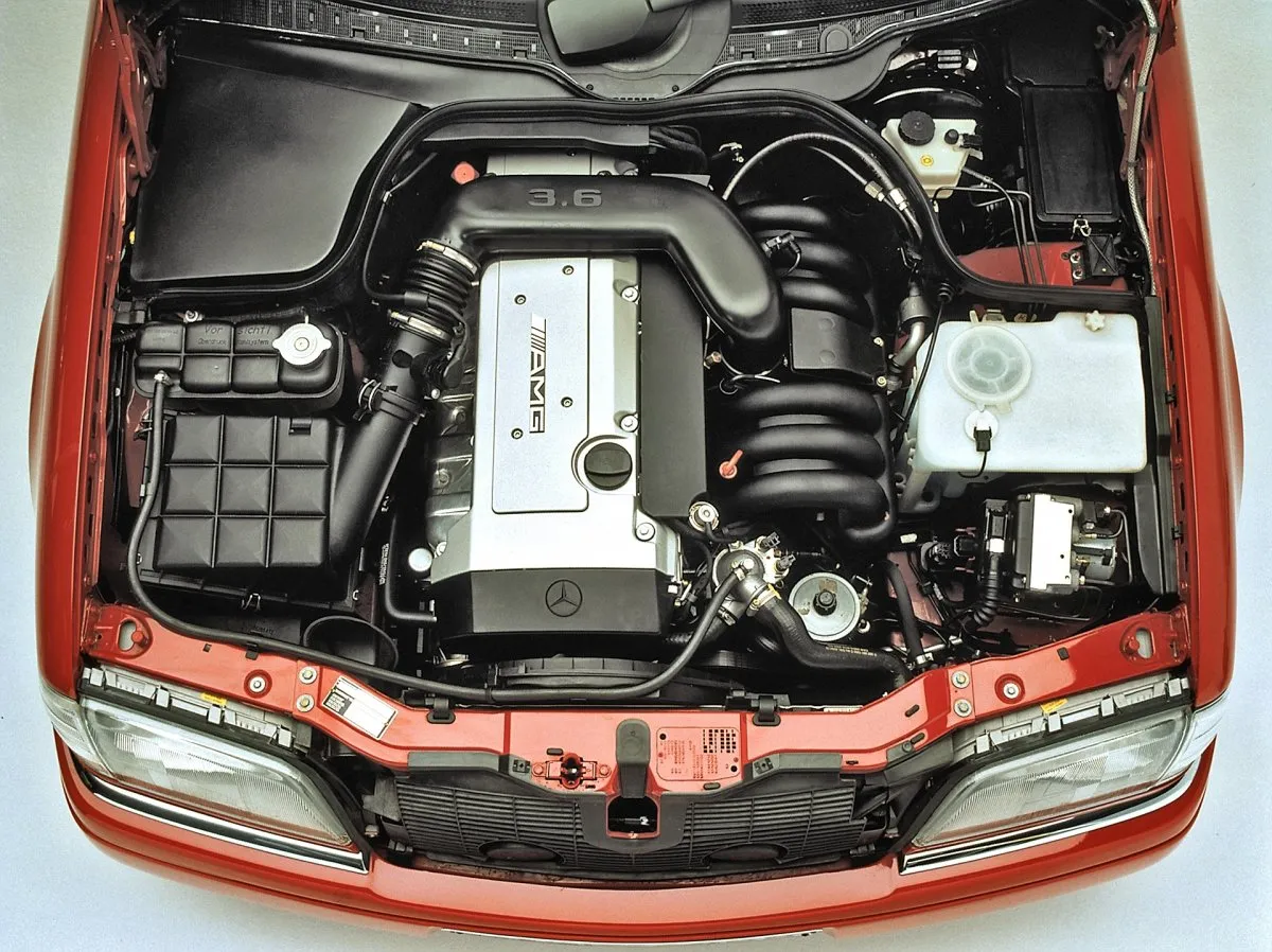 Silnik AMG 3.6 w Mercedes-Benz C Class W202, z widocznym kolektorem dolotowym i osłoną zaworów.
