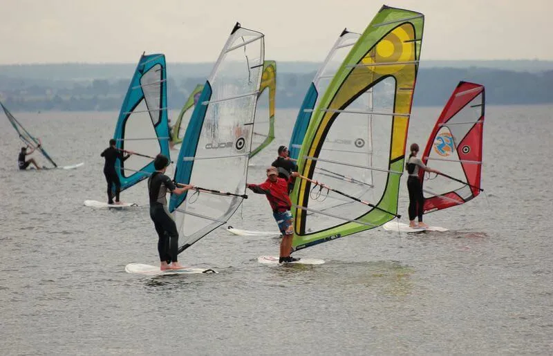 nastolatkowie uprawiający sporty wodne na plaży, windsurfing bałtyk
