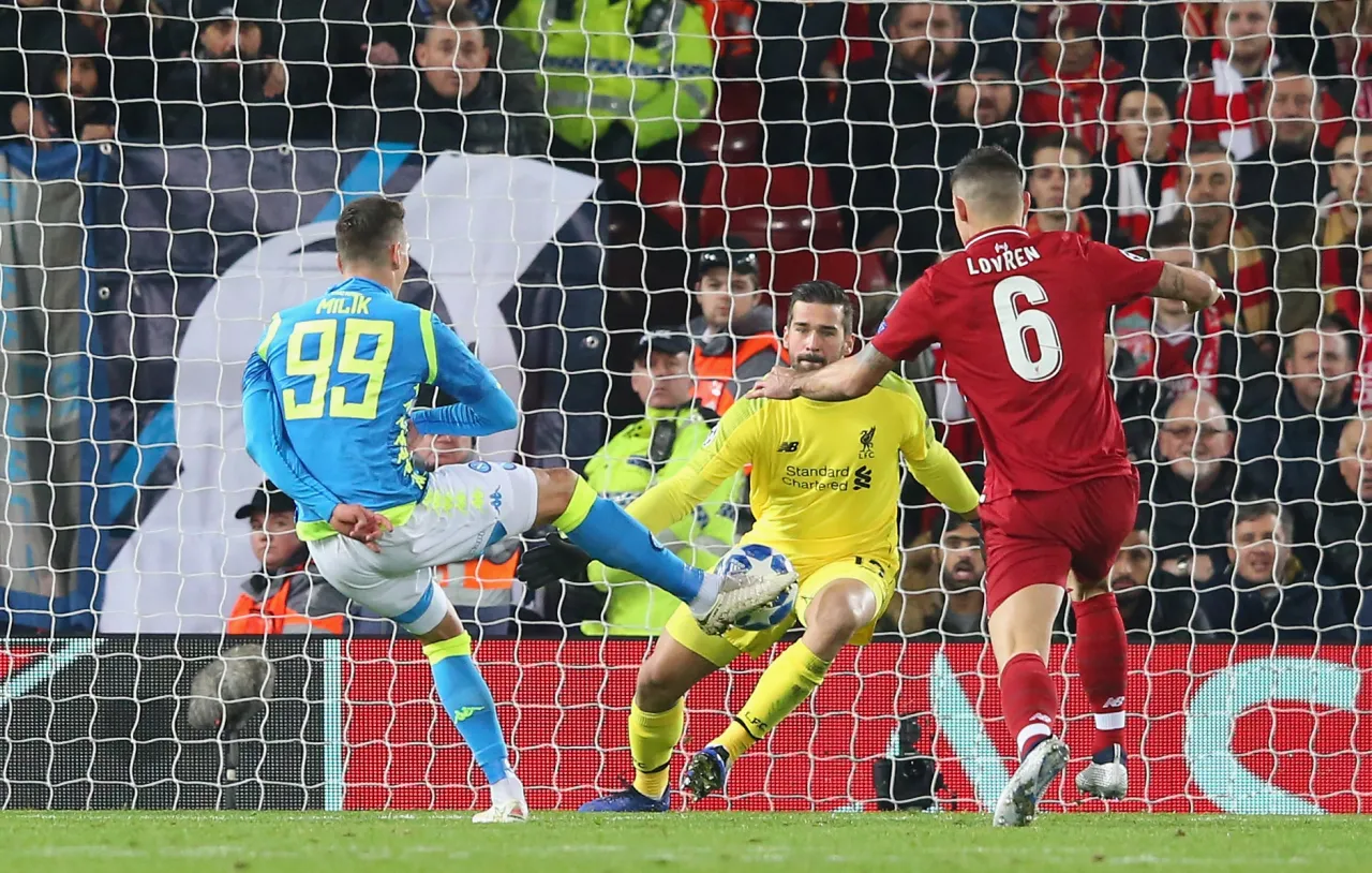 Piłkarz Napoli z numerem 99 pr&oacute;buje strzelić gola, ale bramkarz Liverpoolu, Alisson, broni. To był ważny mecz dla Liverpoolu, kt&oacute;ry wielokrotnie wygrał Ligę Mistrz&oacute;w.