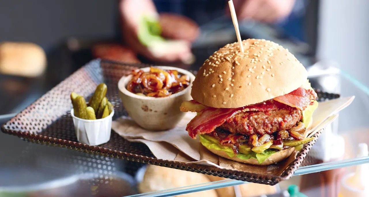 burger avec diff&eacute;rentes garnitures comme oignons caram&eacute;lis&eacute;s et bacon