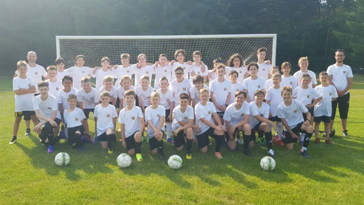 dzieci i dorośli grający w piłkę nożną razem