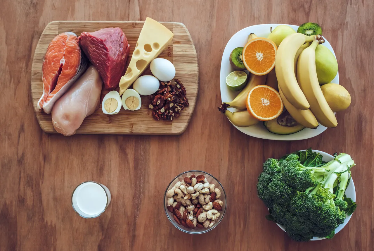 Zdrowe jedzenie wspierające jakie witaminy przy treningu siłowym: ryby, mięso, jajka, nabiał, orzechy, owoce, warzywa.