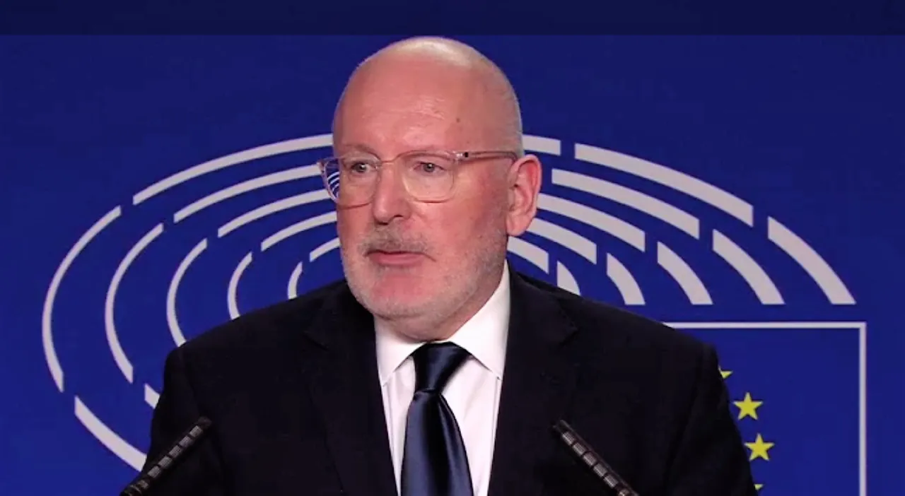 Mężczyzna w okularach, w garniturze, przemawia na tle symboli Unii Europejskiej. To on, Frans Timmermans, jest często kojarzony z tym, kto wymyślił Zielony Ład w Unii Europejskiej.
